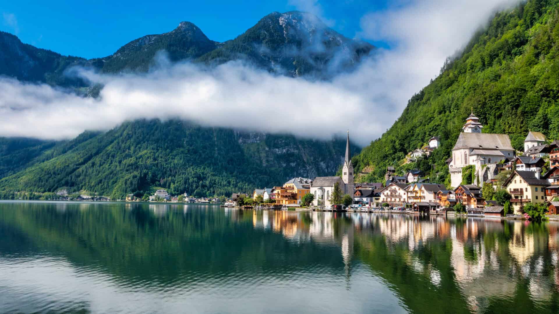 Oberosterreich village pictured on a lake with the mountains behind