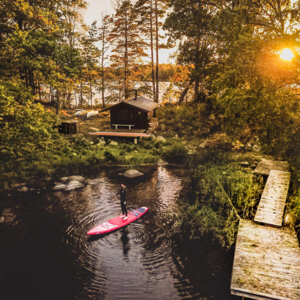 Skåne cabin with a man paddling on a SUP in river